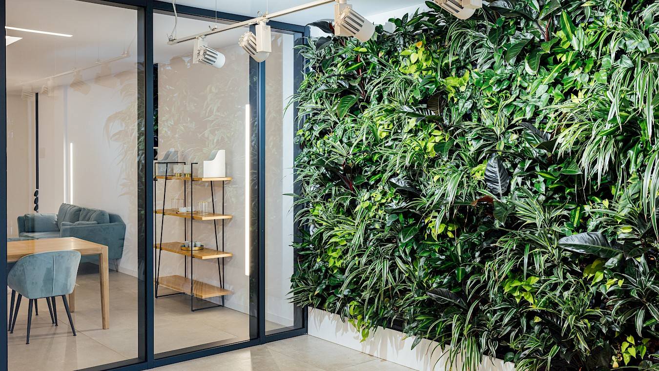 Groene plantenwand met planten en verlichting in kantoor